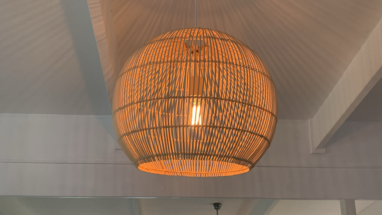 Large woven globe pendant hanging from a raked ceiling