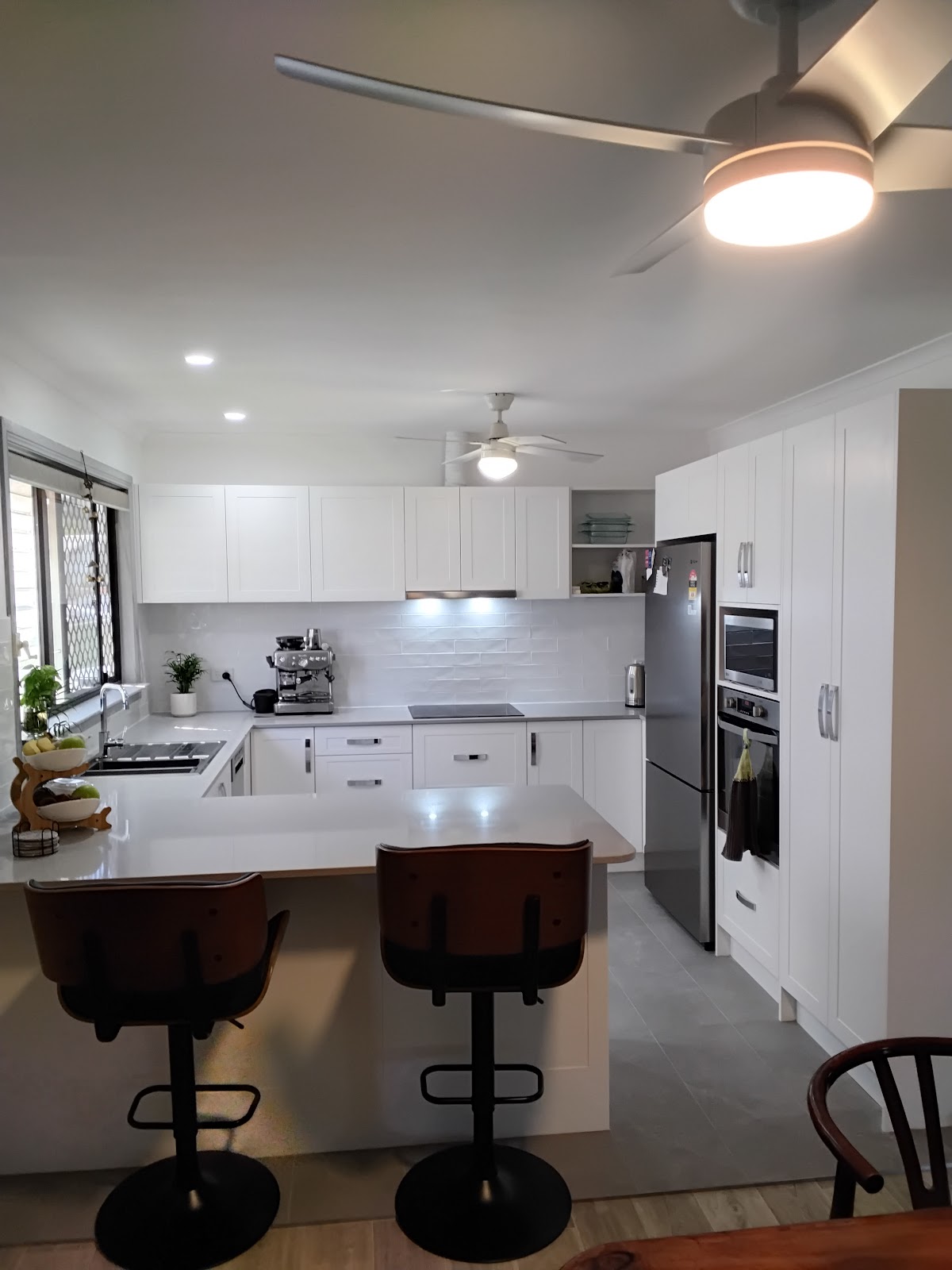 White kitchen with ceiling fans with lights and LED downlights