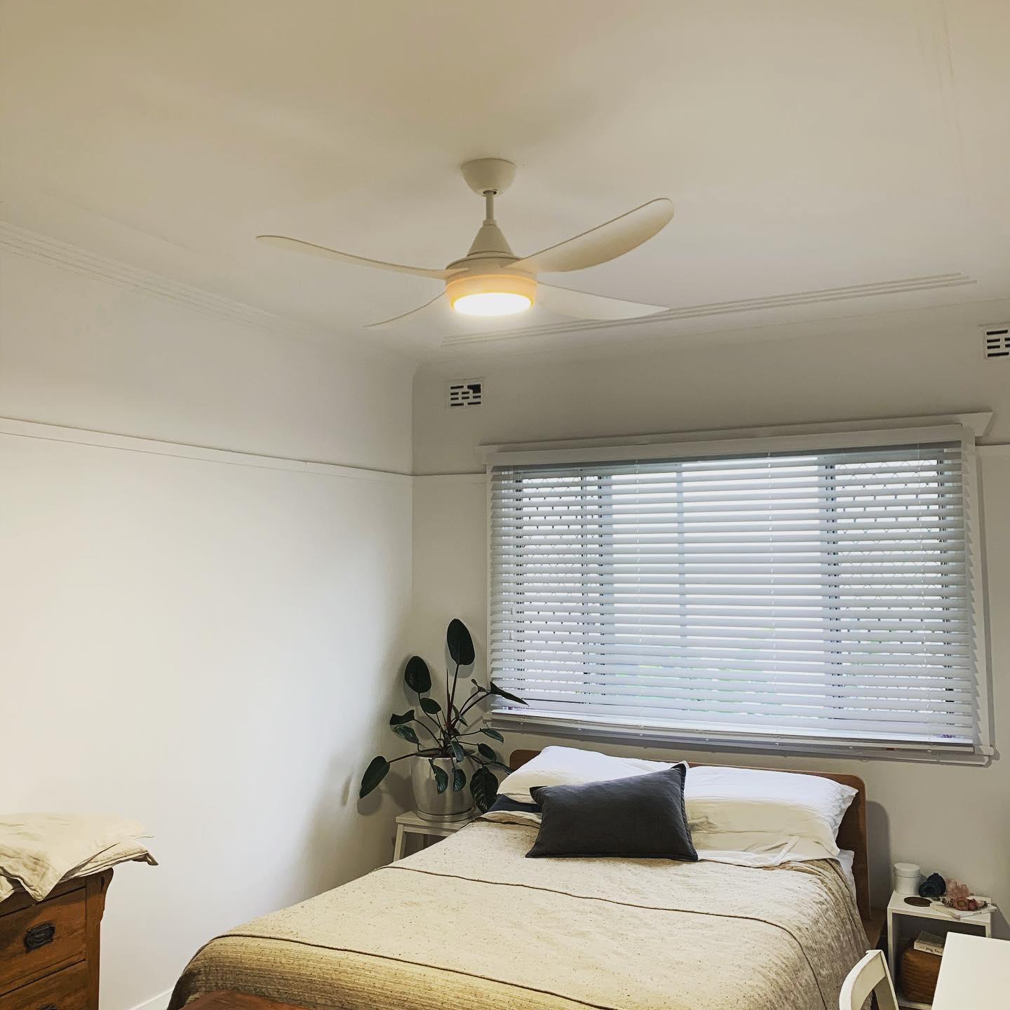 White three-blade ceiling fan with a light in a bright bedroom