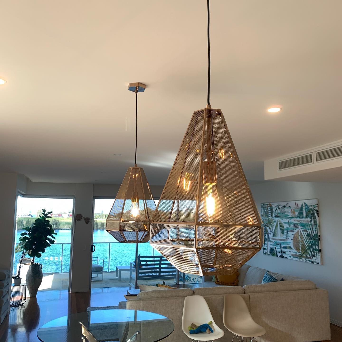 Pair of copper pendant lights with LED filament lamps over a dining table